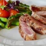 Gegrilde steak met asperges en tomaten.