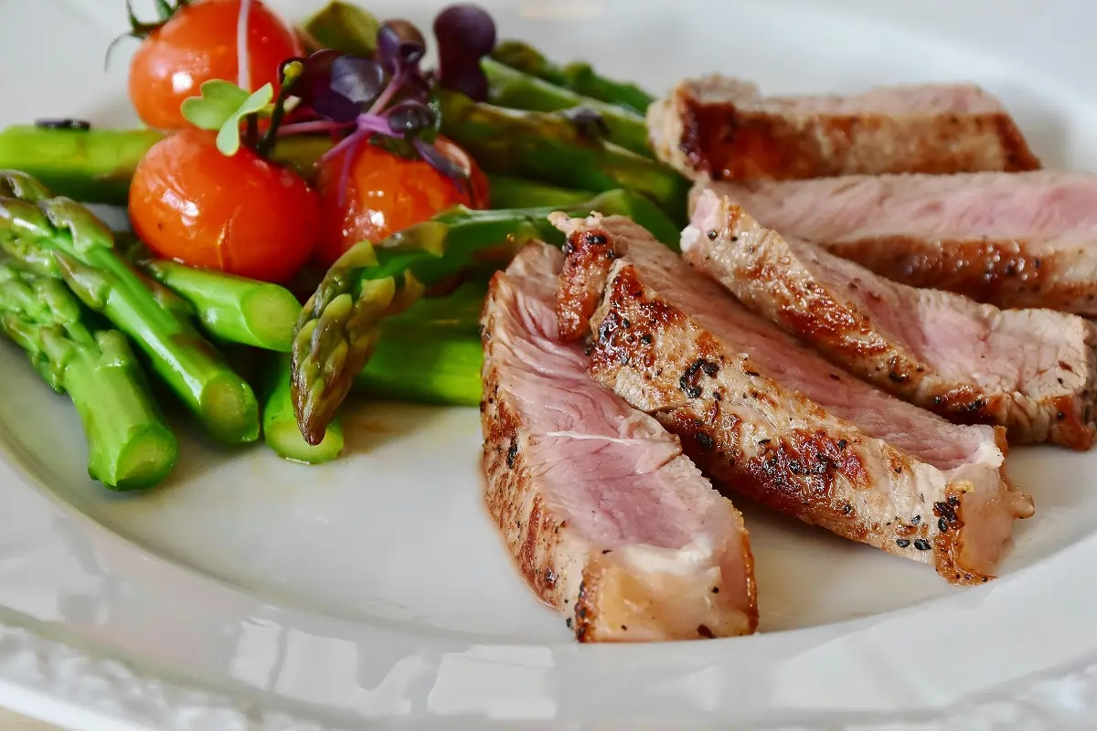 Gegrilde steak met asperges en tomaten.