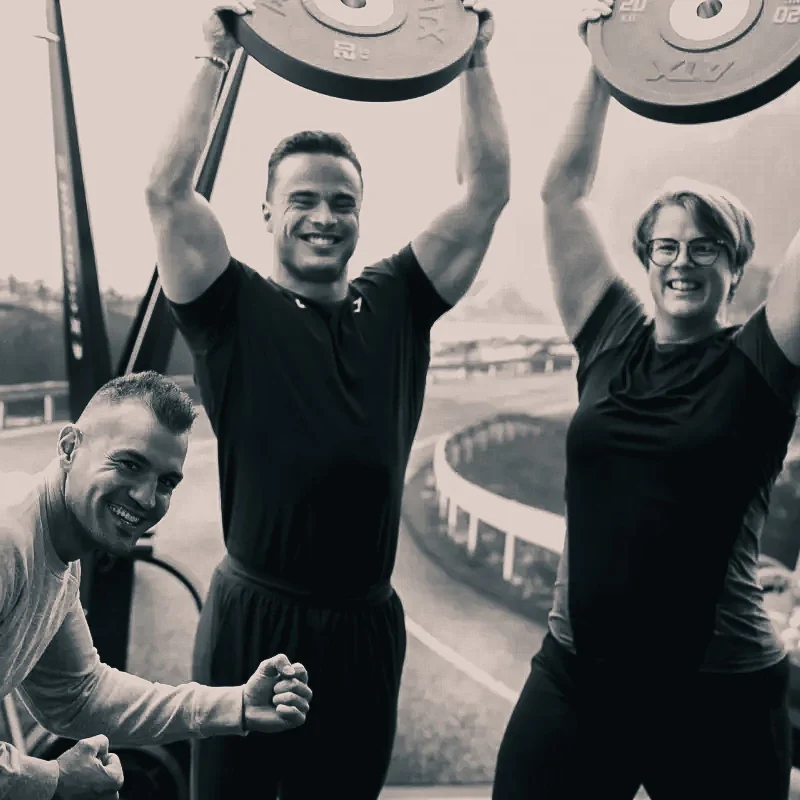 Mensen trainen en gewichten heffen in sportschool