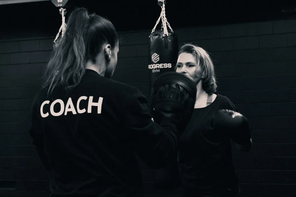 Coach en bokser training in sportschool.